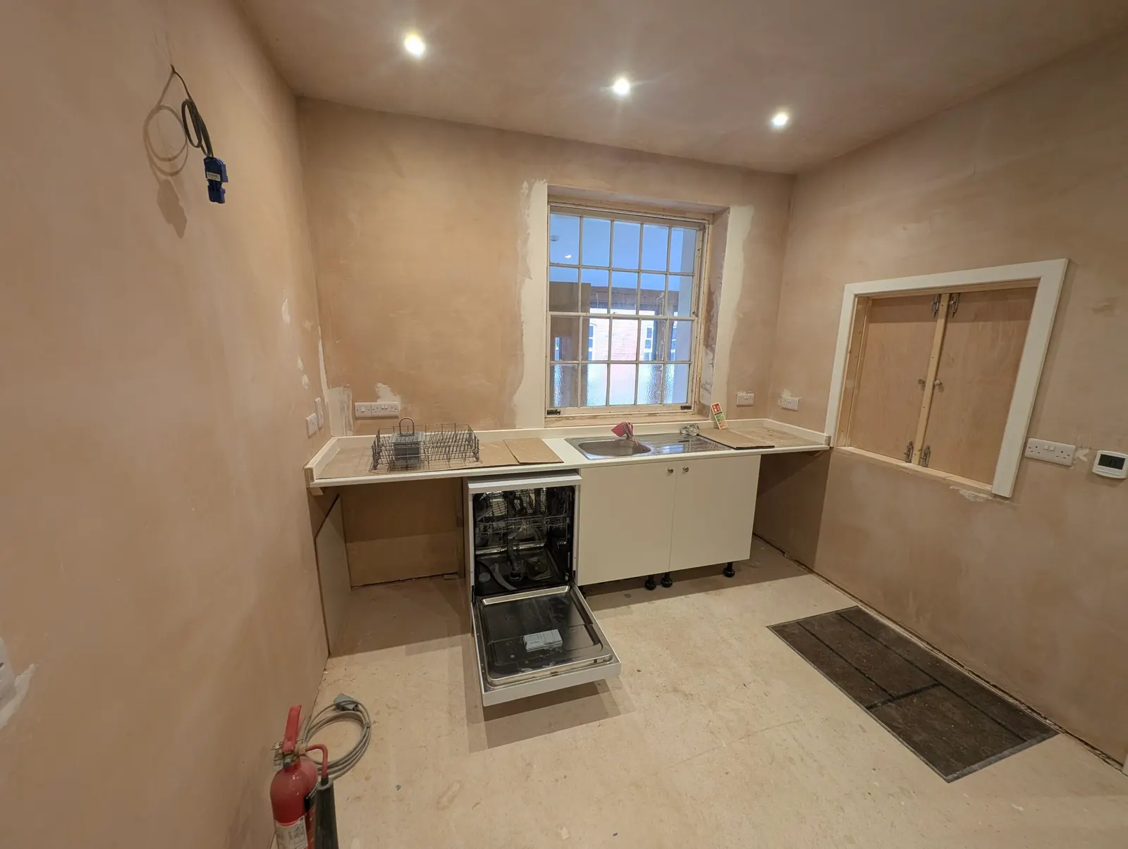 The new kitchen counter, sink and dishwasher installed beneath the window