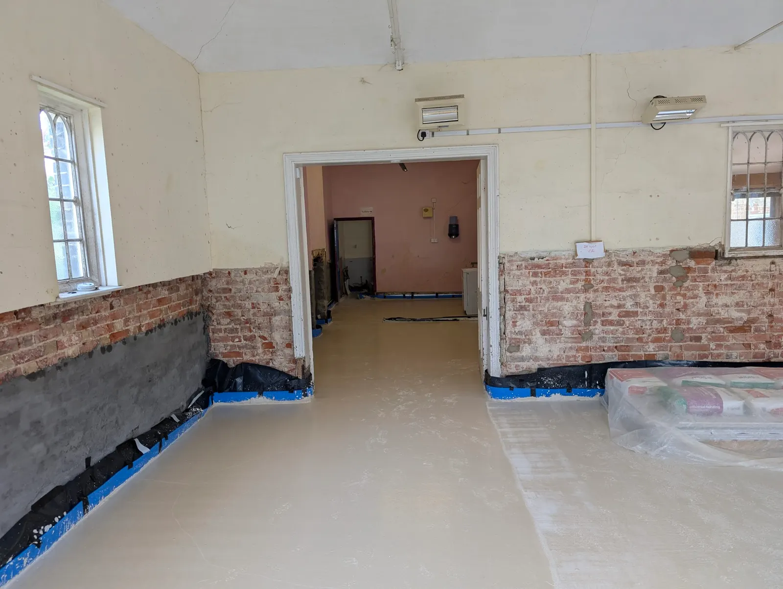 The screeded hall floor, seen through to the corridor and toilets beyond