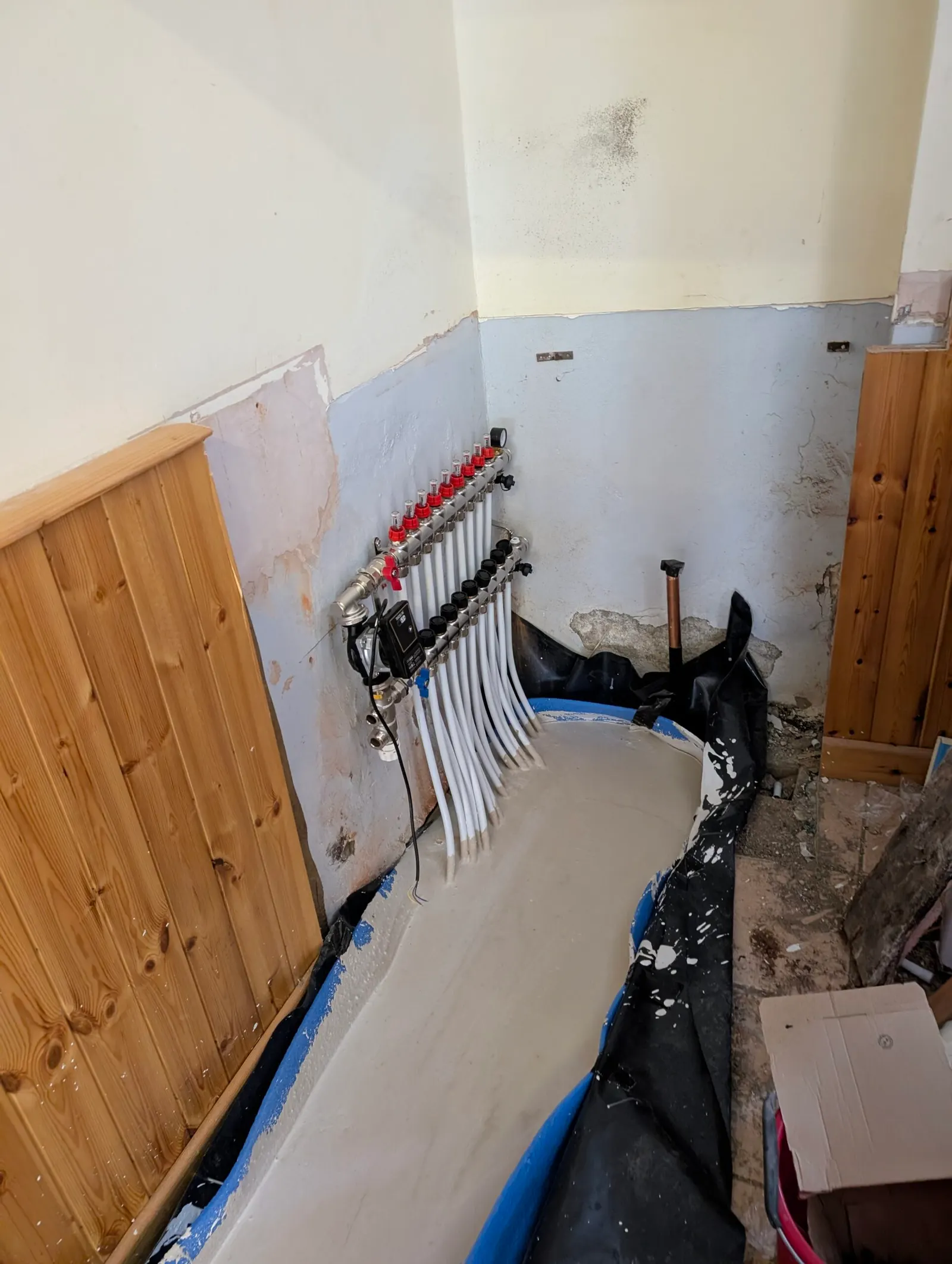 The underfloor heating manifold and pipework installed in the plant room